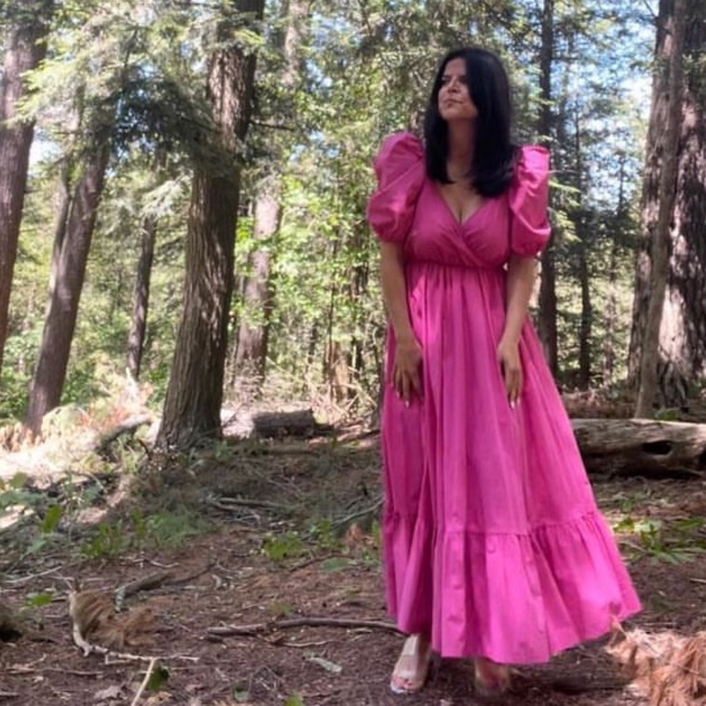Long pink dress with puffy sleeves.
